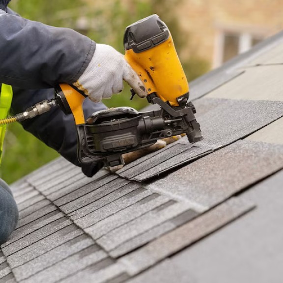a person nailing shingles to a roof